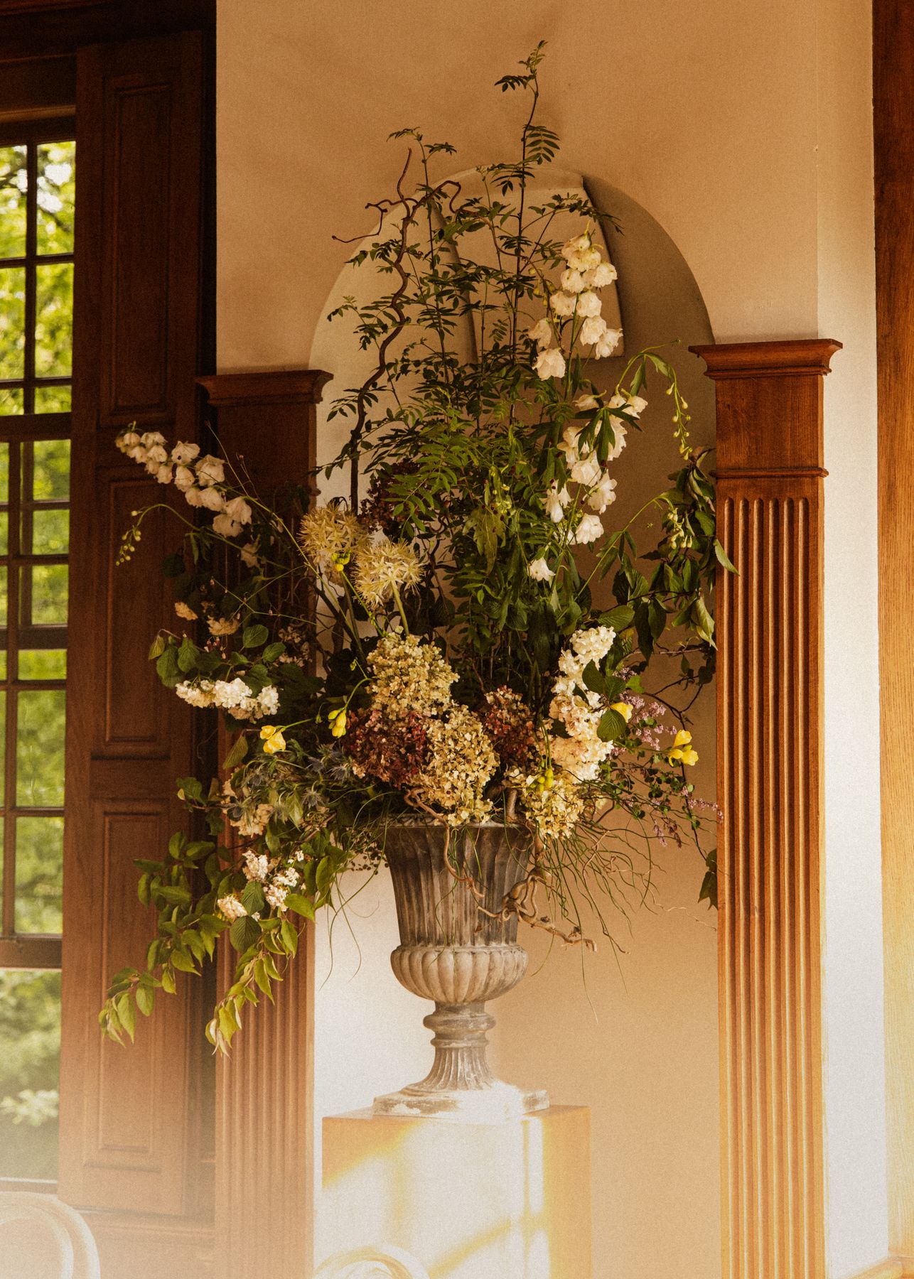 Urn met bloemen in een nis bij avondlicht