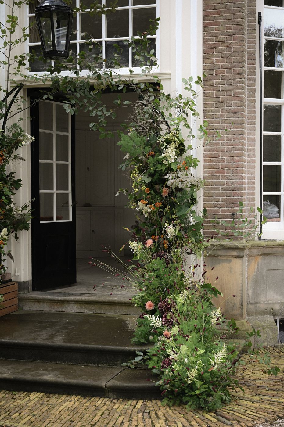 Bloeminstallatie langs een openstaande deur